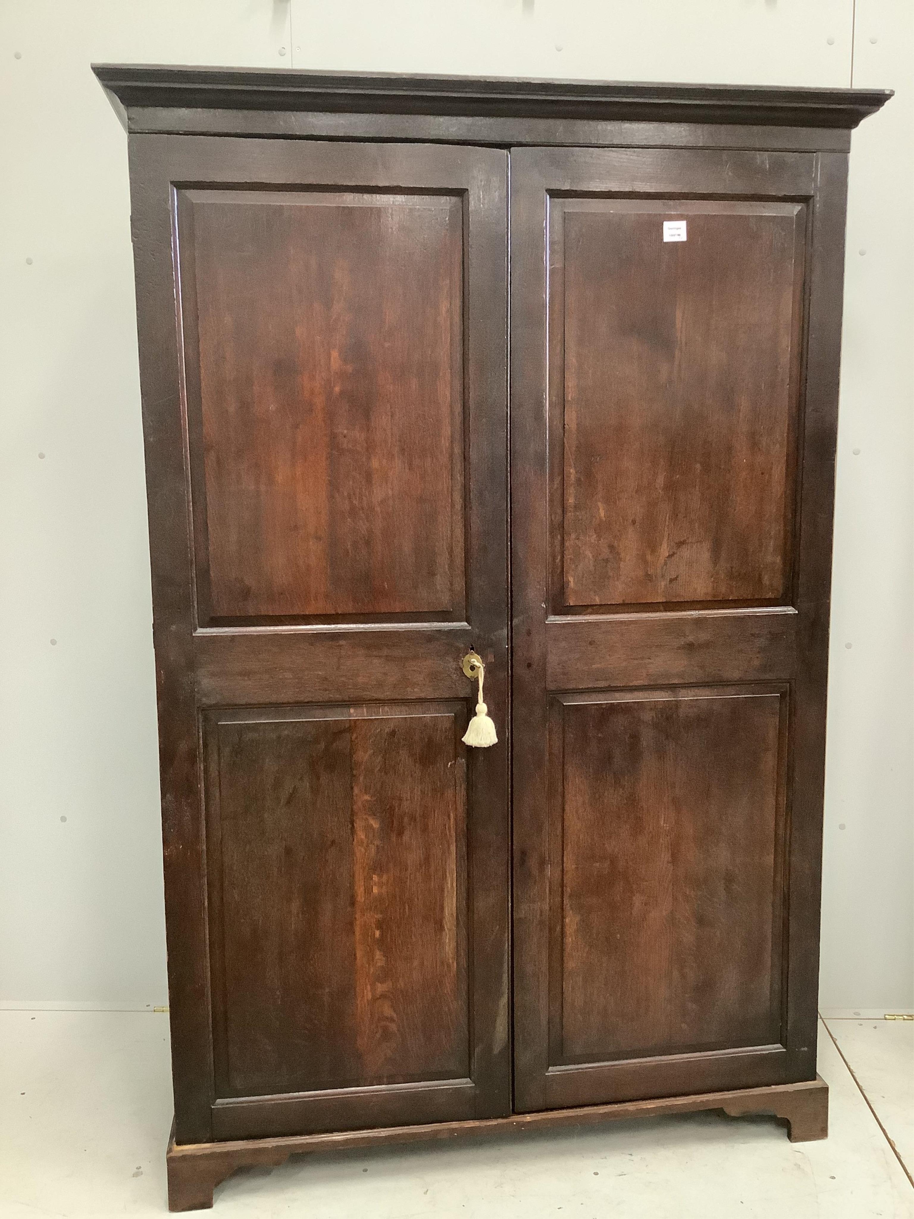 An oak wardrobe, enclosed by a pair of fielded panelled doors, width 130cm, depth 49cm, height 194cm. Condition - poor